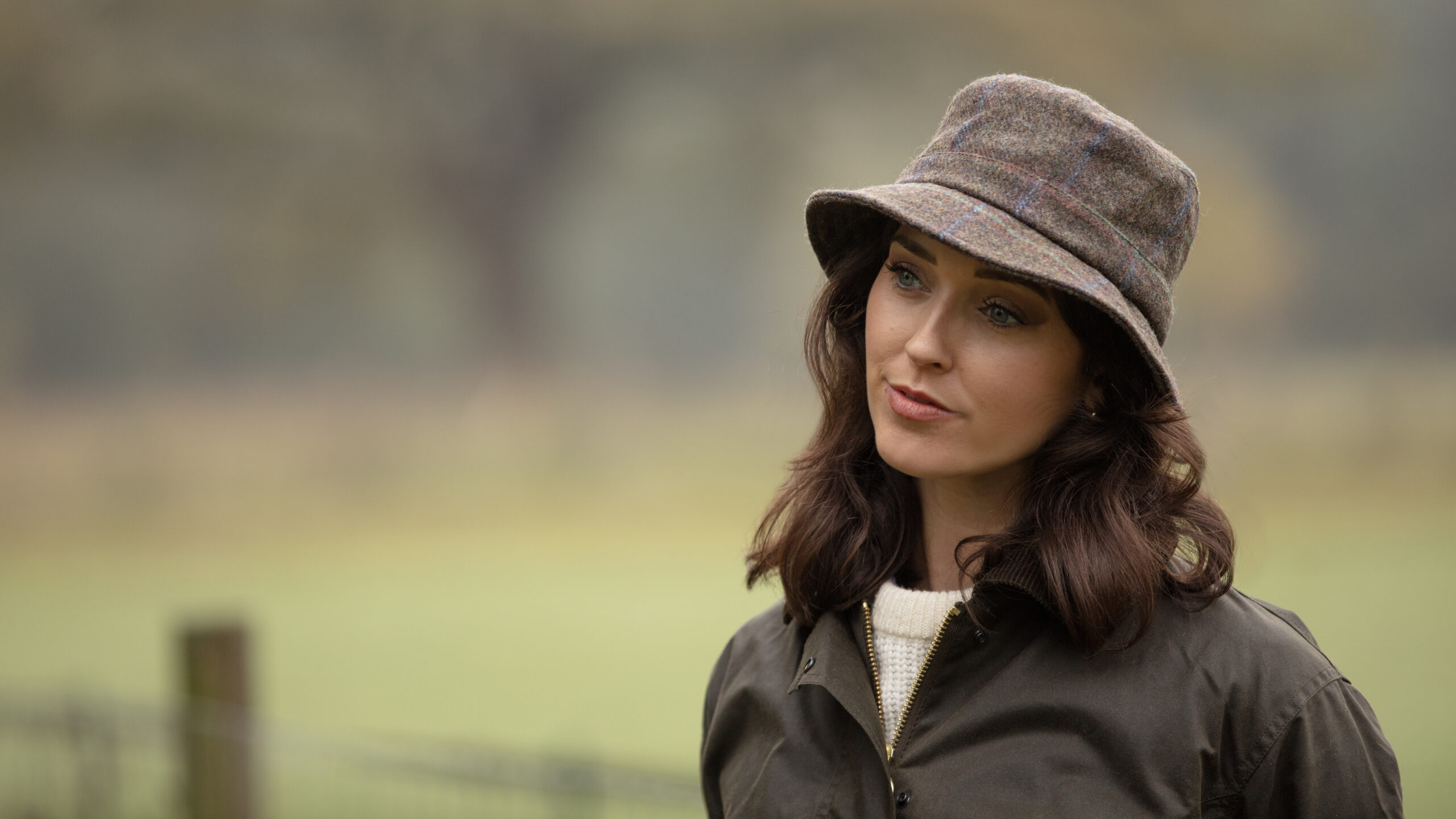 Woman wearing a tweed hat.