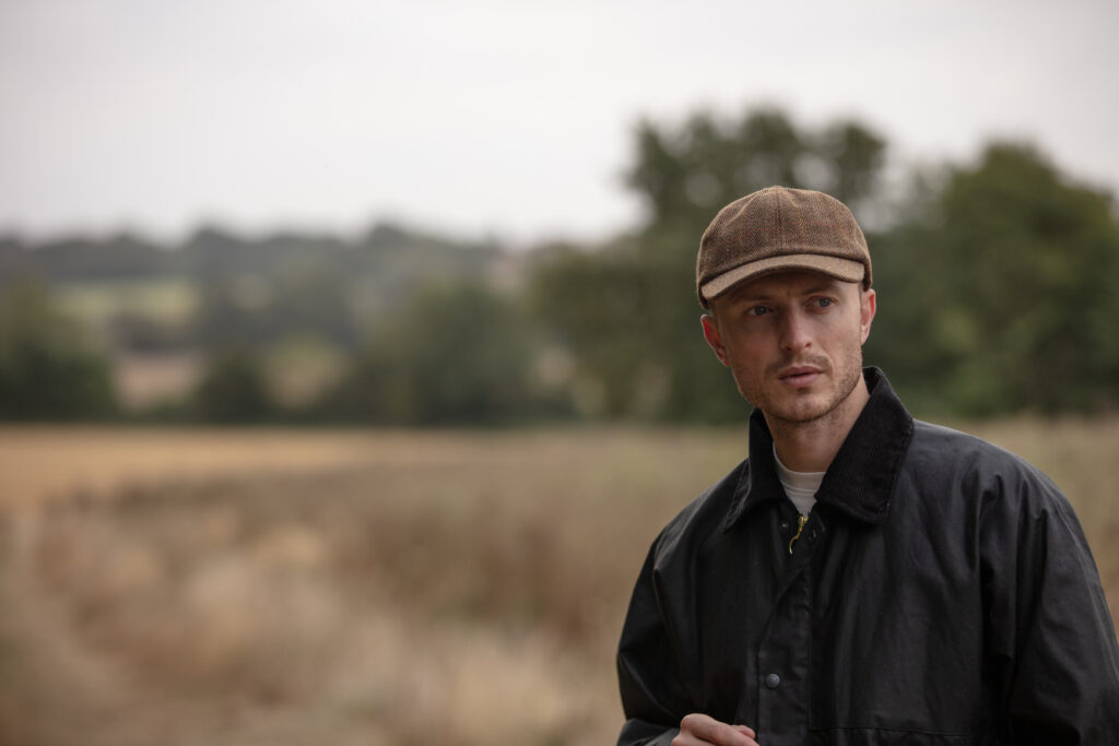 Man wearing a tweed baseball cap.